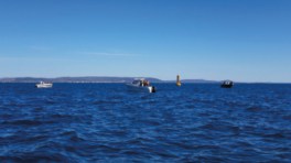 Trois bateaux et un phare flottant dans la mer